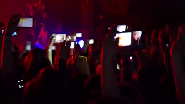 Multidão entretido e fazendo festa em concerto e realizada sobre seus telefones e tablets com telas digitais — Vídeo de Stock