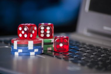 Cips ve dizüstü klavye arka plan üzerinde kırmızı zar kumar