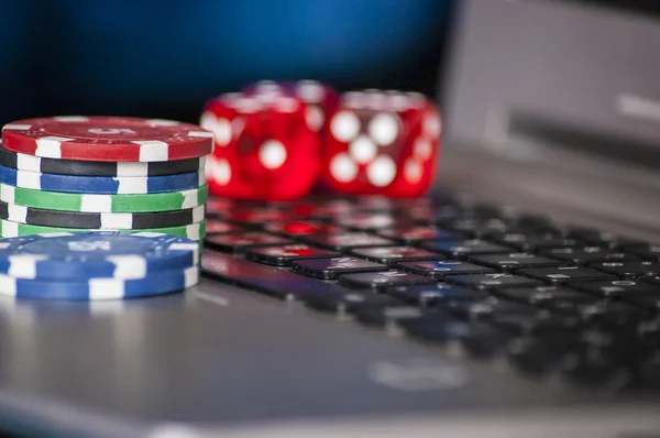 Gambling chips and red dice on laptop keyboard background — Stock Photo, Image