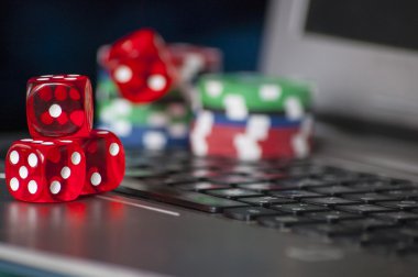 Cips ve dizüstü klavye arka plan üzerinde kırmızı zar kumar