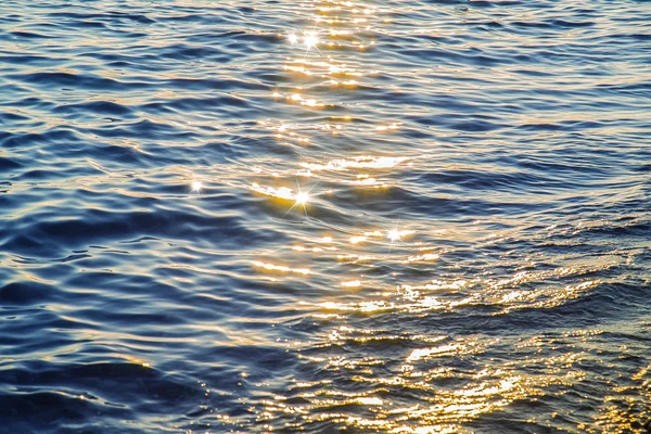 Superfície de água do mar azul ao pôr-do-sol com faíscas — Fotografia de Stock