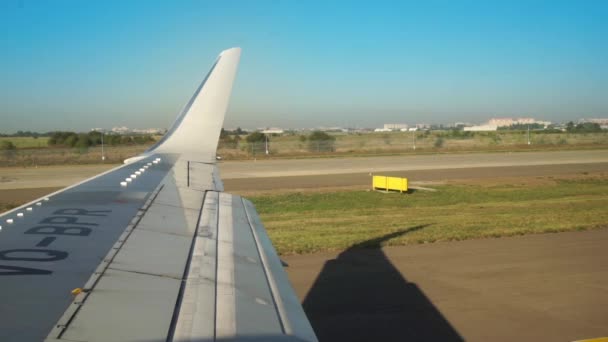 Krasnodar, Rusia - 08 de septiembre de 2016, Vista del ala del avión desde la ventana mientras conduce en la pista y la aceleración antes de despegar otra tabla UTair — Vídeo de stock