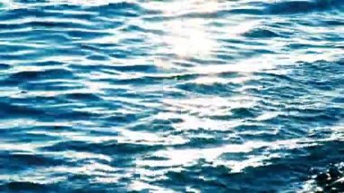 Mavi deniz su yüzeyi sparks ile gün batımında