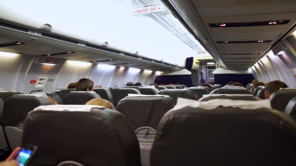 Interior do avião com passageiros em assentos à espera de descolar . — Vídeo de Stock