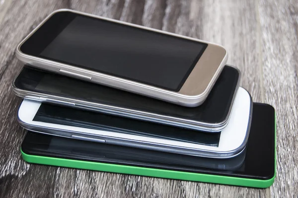 Ahşap arka plan üzerinde birçok akıllı telefonlar