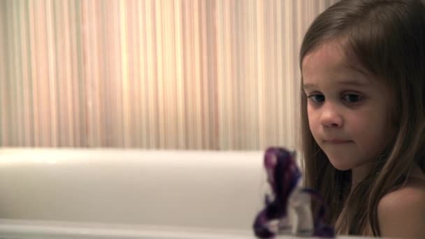 Küçük kız oyun bir banyoda hidromasajlı küvet — Stok video