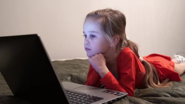 Malá holčička v noci sledovat kreslené filmy na počítači. — Stock video