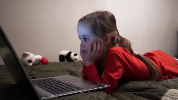 Niña por la noche viendo dibujos animados en la computadora . — Vídeo de stock