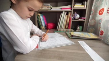 Yazma ve ev ödevi yaparken küçük kız.