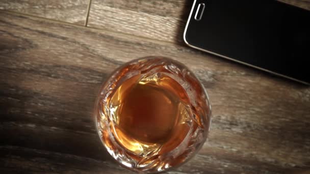 Bicchieri di whisky con ghiaccio sul tavolo di legno. — Video Stock