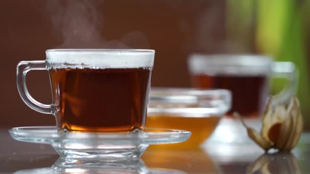 Transparante kopje thee op de tafel — Stockvideo