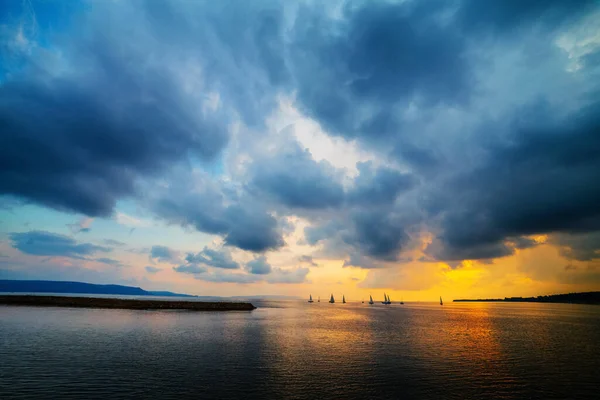 Gün batımında yatlar denizde, adaların arasında. Yatlarda spor haberleri. Altın gün batımı.