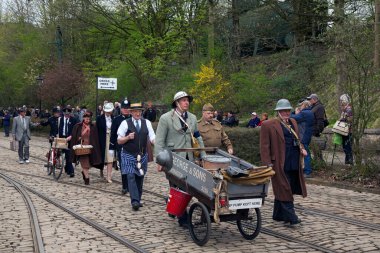 CRICH, ENGLAND - 17 Nisan 2017: II. Dünya Savaşı - 1940 'larda Derbyshire' daki Crich Tramway Village 'da tarihi karayolu, askeri araçlar ve 1940' ların kostümlü insanlar ile ev cephesi etkinliği. Ziyaretçiler, Ulusal Tr 'nin klasik tramvaylarına da binebilirler.
