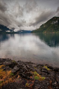 Gölün uzak tarafında alçak bulut ile portre biçiminde Crescent Gölü görüntüsü.