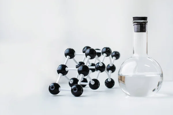 Molecule model of a substance on a white background. Liquid substance in a flask. Atoms of matter and their structure. Molecular bonds. Substance in a flask.