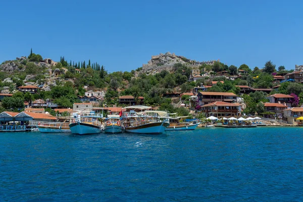 Deniz kenarındaki köy. Demir atmış gemi, yat. Gökyüzü, temiz su.