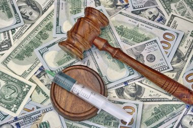 Judges Gavel And Syringe With Injection On Dollar Cash Backgroun clipart