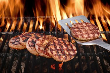 Beef Burgers On The Hot Flaming BBQ Charcoal Grill clipart