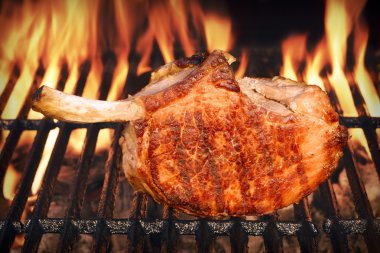 Pork Rib Steak On The Hot Barbecue Flaming Grill clipart