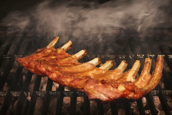 BBQ arrosto bambino indietro maiale costole su caldo fiammeggiante griglia — Foto Stock