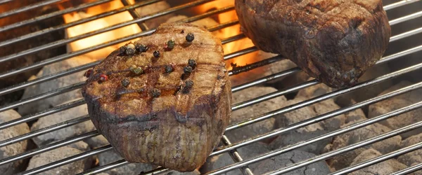 Medalhões de filé de carne grelhada na grade de churrasco flamejante — Fotografia de Stock