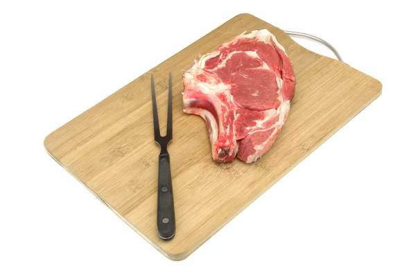 Surowy stek wołowy, widelec na drewno deska do krojenia izolowane — Zdjęcie stockowe