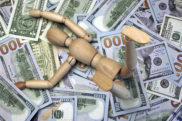 Figura humana de madera en el fondo de efectivo del dólar —  Fotos de Stock