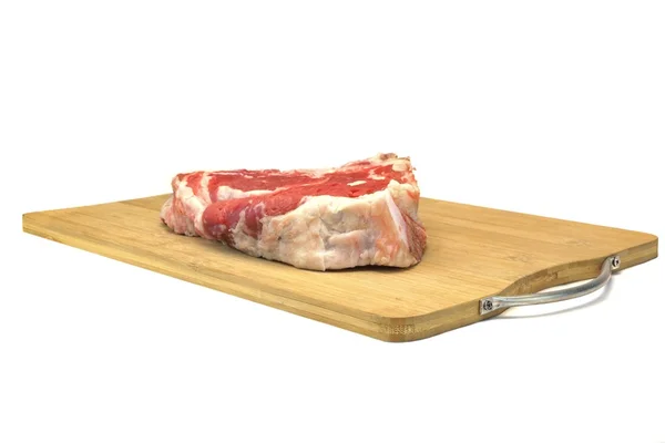 Filete crudo de carne de res Ribeye en el tablero de corte de madera aislado —  Fotos de Stock