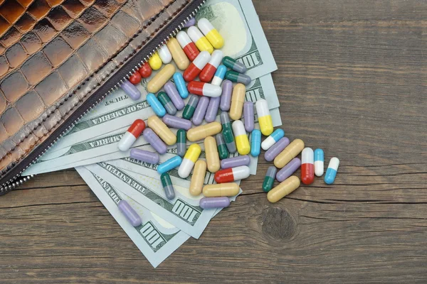Pénztárca amerikai dollárral készpénz és gyógyszer a fa háttér — Stock Fotó