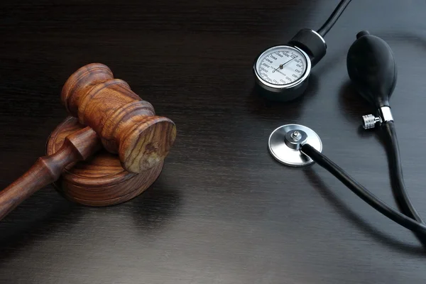 Judges Gavel And Medical Equipment On Black Wooden Background — Stock Photo, Image