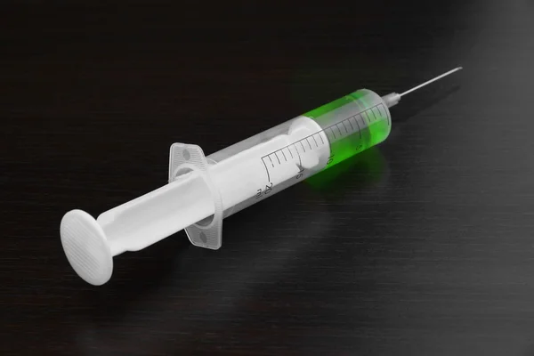Single Syringe With Green Liquid On The Black Wood  Background — Stock Photo, Image