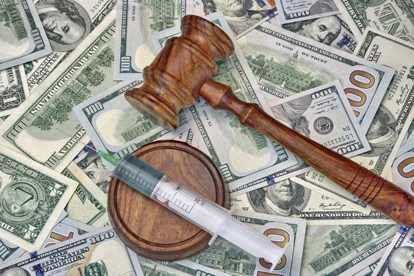 Judges Gavel And Syringe With Injection On Dollar Cash Backgroun