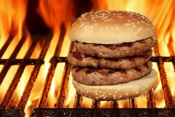 Hambúrguer grande caseiro na churrasqueira em chamas quente — Fotografia de Stock