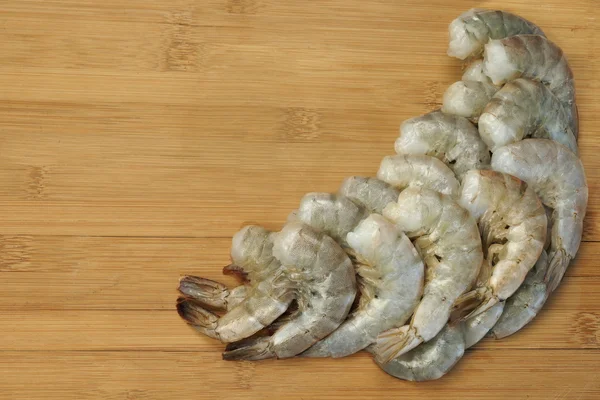 Beaucoup de crevettes vertes crues King Size sur fond en bois — Photo