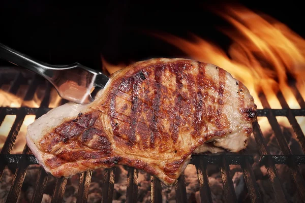 포크로 뜨거운 불타는 바베 큐 그릴에 돼지고기 스테이크 — 스톡 사진