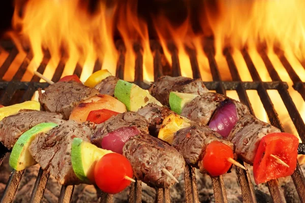 Quatre brochettes de boeuf rôties avec des légumes sur barbecue grill flamboyant — Photo