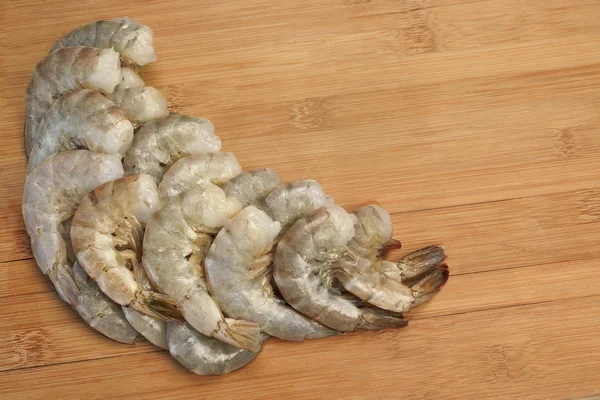 Beaucoup de crevettes vertes crues King Size sur fond en bois — Photo