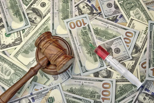 Судьи молоток и шприц с инъекцией на долларовой наличности Backgroun — стоковое фото