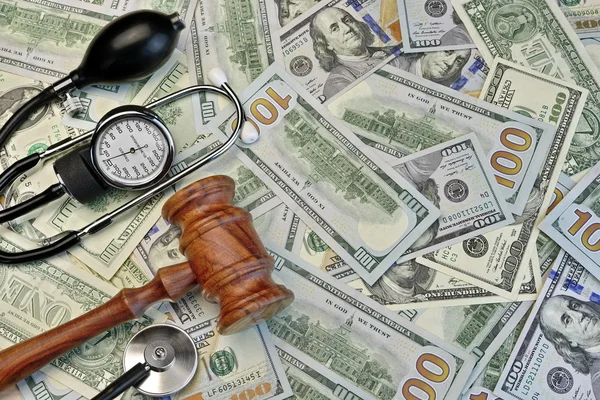 Судді Гевель та медичні інструменти на фоні готівки доларів — стокове фото