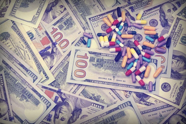 Різні ліки на фоні готівки долара — стокове фото