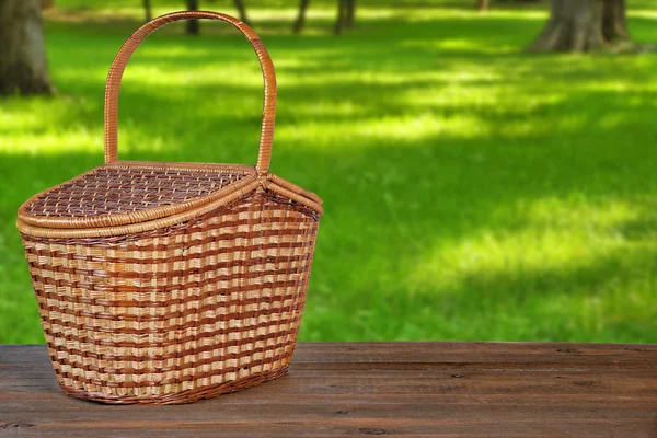 Cesta de picnic o cesta en banco de madera en el parque — Foto de Stock