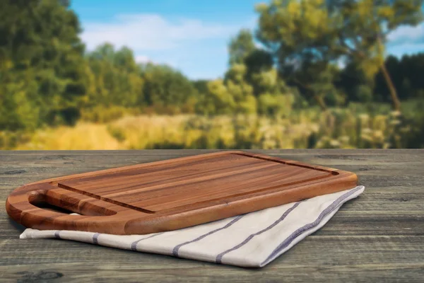 Wooden Cutting Board Close-up On The Picnic Table And Summer Lan — Stockfoto