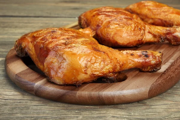 Trimestre de cuisse de poulet barbecue grillé trois sur panneau de bois — Photo