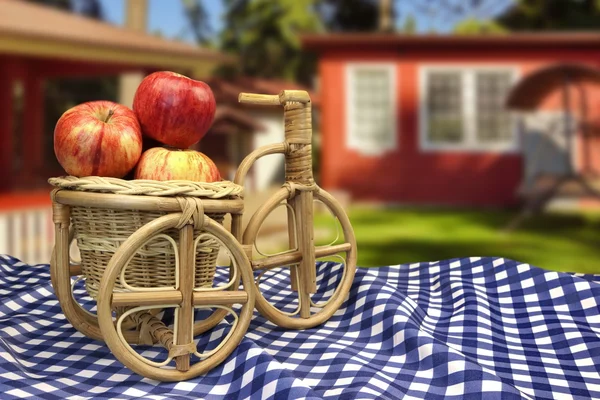 Wicker Bicycle Basket With Apples On Table With Blue Tablecloth — Zdjęcie stockowe