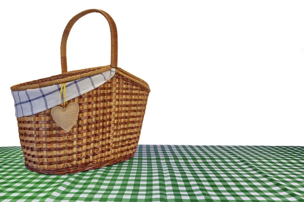 Whit üzerinde izole yeşil kareli masa örtüsü üzerinde piknik sepeti — Stok fotoğraf