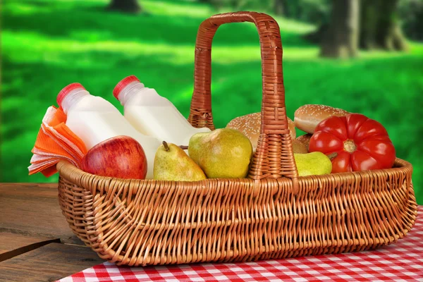 Kosz piknikowy z jedzeniem i piciem na stole — Zdjęcie stockowe