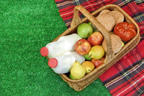 Cesta de mimbre con comida y bebida en la manta de picnic —  Fotos de Stock