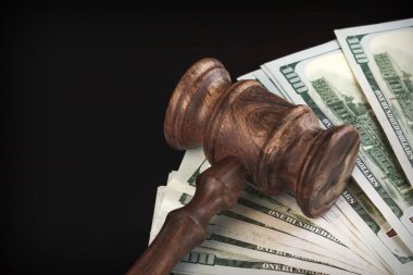 Judges Hammer or Gavel With Money Heap On Black Background clipart