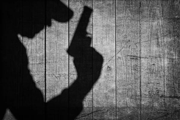 Schwarz bewaffnete männliche Silhouette auf dem Holzzaun. — Stockfoto