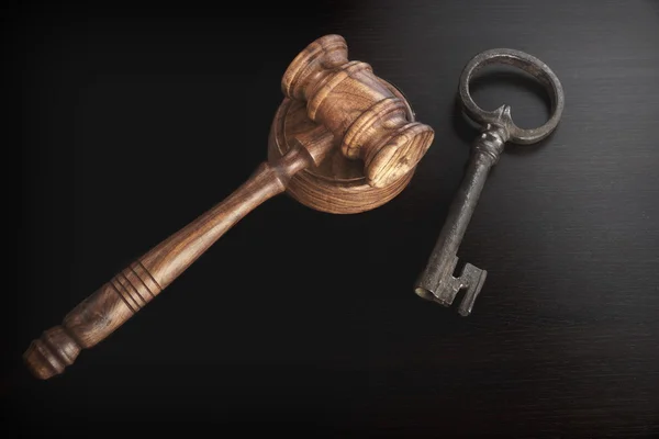Soudci kladivo nebo kladívko se starým klíčem na tmavém pozadí — Stock fotografie